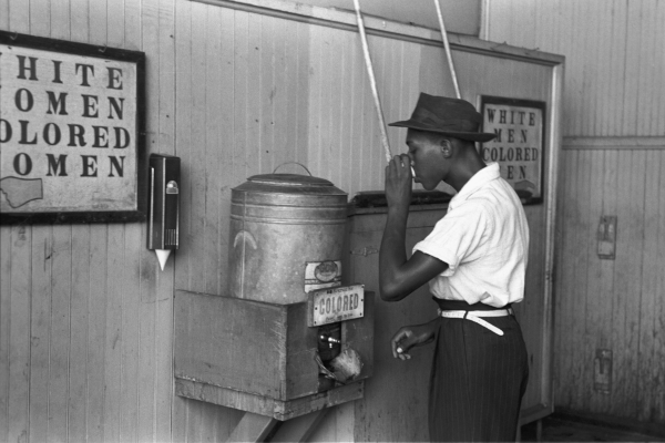 Black Man During Segragation Black man drinking water at a